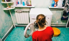 Caucasian woman loading laundry in dryer<br>FF0WGP Caucasian woman loading laundry in dryer