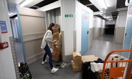 Boxes of books are transferred from an orange trolley to a lock-up