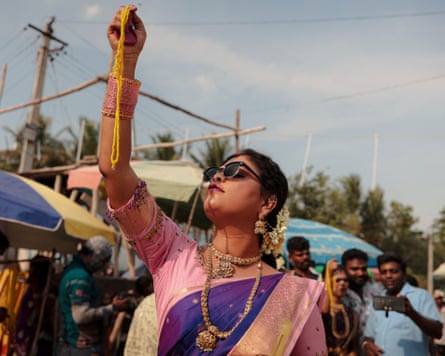 Woman at Koovagam festival holding a yellow thread aloft