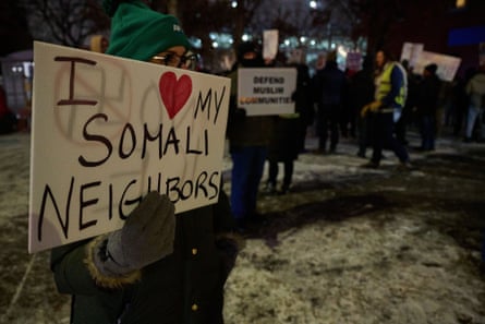 a person holds a sign that reads ‘I love my Somali neighbors’