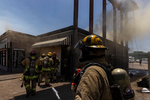 Firefighters in the foreground of a burning building