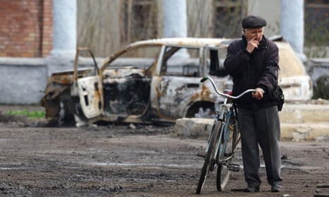 A villager is seen near a burnt-out car during heavy fighting at the front line of Bakhmut and Chasiv Yar, in Chasiv Yar, Ukraine.