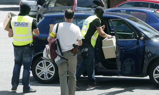 Police officers confiscate materials belonging to the athletics coach Jama Aden, who was arrested at the Arrahona hotel, in Sabadell, Spain on Monday. Photograph: Andreu Dalmau/EPA