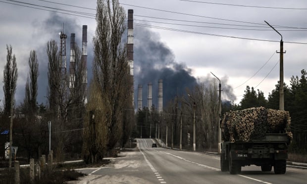 A military vehicle seen as smoke rises from a power plant after shelling outside the town of Schastia, near the eastern Ukraine city of Lugansk, on Tuesday after Russia recognised east Ukraine’s separatist republics and ordered the troops there as ‘peacekeepers’.