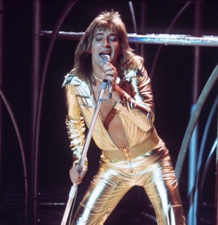 Stewart in gold lame jumpsuit open to the waist
