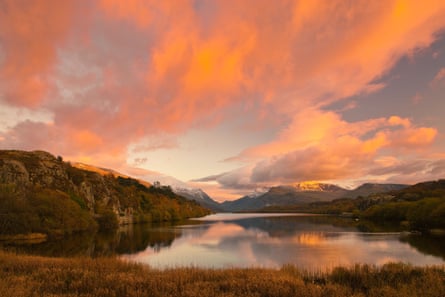 Orange evening sky over Eryi national park in north Wales with reflections in lake.