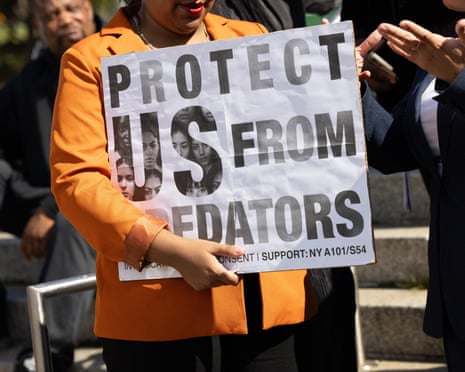 a person holds a sign that reads 'protect us from predators'