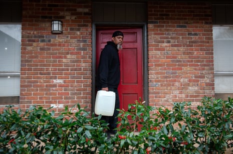Roderick Readus carries a reusable water container outside his apartment in Jackson, Mississippi on March 2, 2021. Photo by Rory Doyle for The Guardian.
