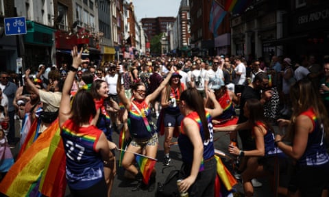 People dancing in street with rainbow flags. eiqridttidekinv