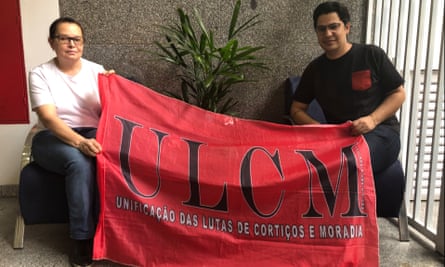 Marli Baffini (left) and Wemerson Silva went from living in tenements to managing the board of Edifício Dandara, a rehabbed downtown São Paulo building. They hold the banner for the tenement dwellers’ organisation that lobbied the ministry for finance.
