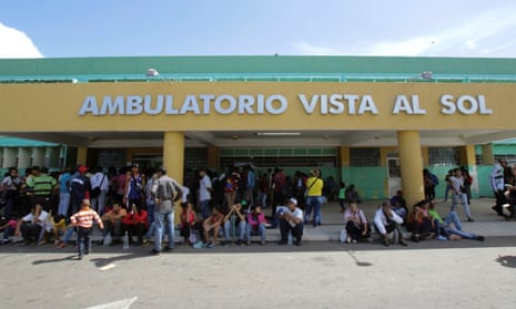 People gather outside a health center as they wait to get treatment for malaria, in San Felix, Venezuela