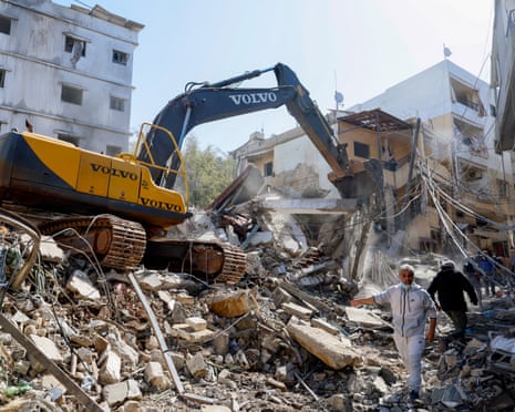 A bulldozer clears the rubble of destroyed buildings