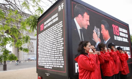 Members of Reporters Without Borders tape their mouths during an action, in front of a truck with a message for 119 journalists currently detained by China, next to the Arc de Triomphe in Paris.