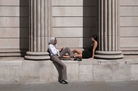 People shade themselves from the sun near the Bank of England in central London