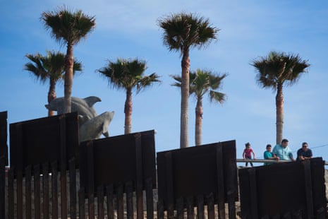 People in Tijuana, Mexico, look over the border fence separating the beaches at Border Field State Park