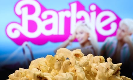 Popcorn held in front of a Barbie movie poster.
