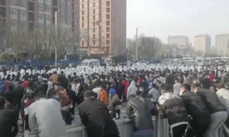Protesters facing off against security personnel in white protective clothing at the factory compound operated by Foxconn Technology Group last week.