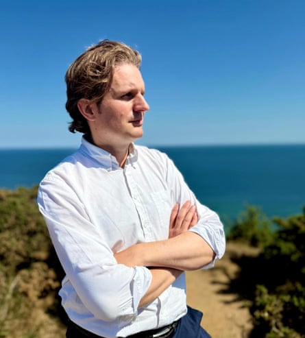 Steff Aquarone stand with folded arms by a beach in North Norfolk on a sunny day.