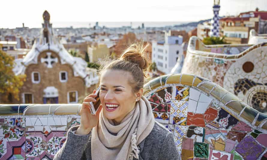 Young woman at Guell Park in Barcelona, Spain speaking on phone