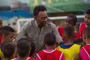 Pelé speaks with children during the inauguration ceremony of a new football pitch installed at Mineira favela in Rio de Janeiro, Brazil, in 2014