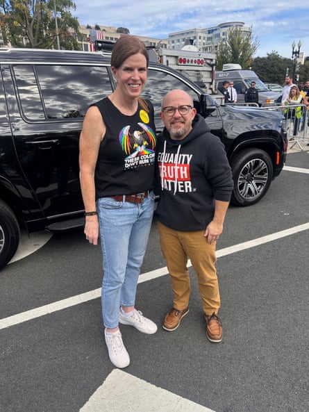 man and woman stand together at protest with one shirt saying ‘these colors don’t run’ with pride flag and the other saying ‘equality truth matter’