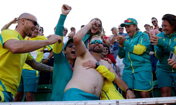 A shirtless Aaron Wilson of celebrates with his Australian team-mates following his victory in the men’s singles gold medal match.