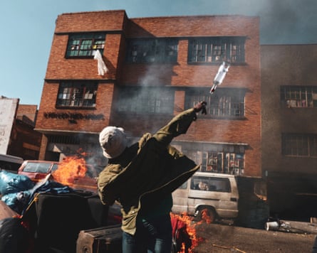 An anti-immigrant demonstrator throws a bottle as items which the demonstrators say belong to foreign nationals burn on the street in Johannesburg, South Africa.