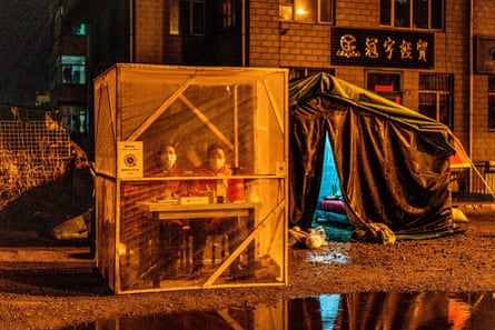 Staff members guard the entrance of a community in Mudanjiang, Heilongjiang province, on 20 April 2020.