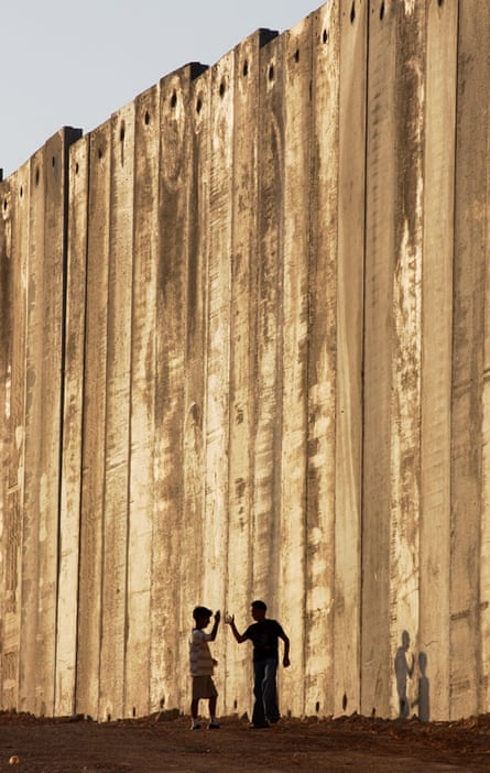 Niños palestinos juegan junto a una sección de la barrera de separación construida por Israel en la ciudad cisjordana de Belén.