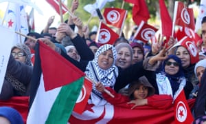 La gente agita banderas nacionales durante las manifestaciones en el séptimo aniversario del derrocamiento de Zine al-Abidine Ben Ali en Túnez.