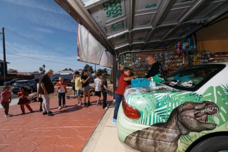 kids line up to play at the dinosaur themed makeshift arcade and funhouse