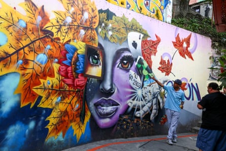 Bir tur rehberi Comuna 13'te turistlere grafiti gösteriyor
