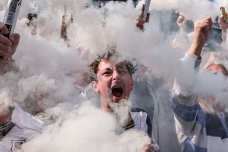 A Tottenham supporter sets off a flare as the team bus arrives.