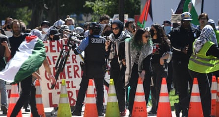 a group of people with signs near a row of cones