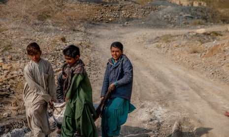 Kids carrying a sack of coal to sell on the main road in Mach, Balochistan.