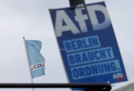 An AfD campaign poster is fastened to a post in front of a pale blue CDU flag in Berlin. The poster reads 'Berlin braucht ordnung' ('Berlin needs order').