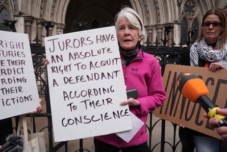 Warner holding a sign reading ‘jurors have an absolute right to acquit a defendant according to their conscience’