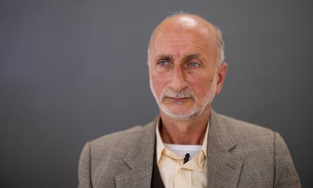 A slim, 60-year-old Palestinian man with a bald head and a white beard