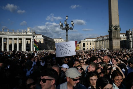 A man holds a placard reading “Habemus Papa” (We Have a Pope) after white smoke rose from the chimney of the Sistine Chapel.