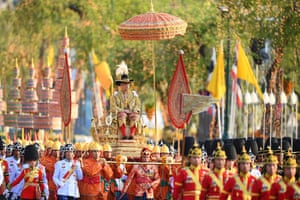 Thailand's King Maha Vajiralongkorn is carried in a golden palanquin during the coronation procession, as Princess Bajrakitiyabha Mahidol and Queen Suthida walk alongside