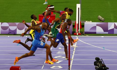 Noah Lyles, in lane seven, crosses the line to win gold in the men's 100m final in Paris.