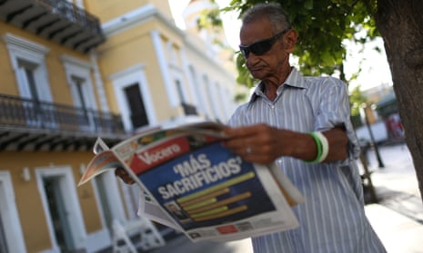 José Vásquez reads a newspaper with a Spanish headline that reads, ‘More sacrifices’, a day after Puerto Rico’s governor, Alejandro García Padilla, gave a speech about the territory’s $72bn debt.