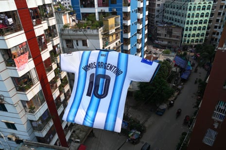 A giant Argentina national football team jersey hangs between two residential buildings in the Ibrahimpur neighborhood of Dhaka, Bangladesh.
