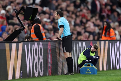 Referee Darren England watches the pitchside VAR monitor before ruling out a goal by Daniel Ballard