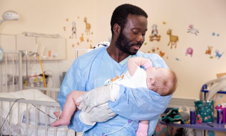 Samuel, a nursery nurse at the Brompton holds Lottie-Mae, 6 months, who has been at the hospital since she was born.