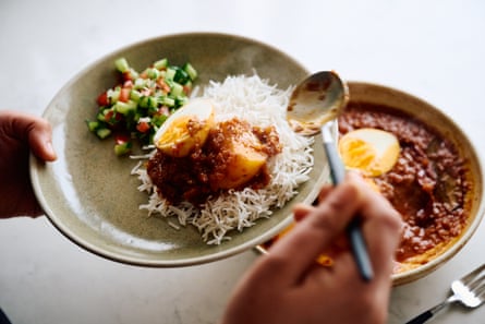 An egg curry served with some rice and salad.