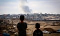Boys watch smoke billowing during Israeli strikes east of Rafah in the southern Gaza Strip
