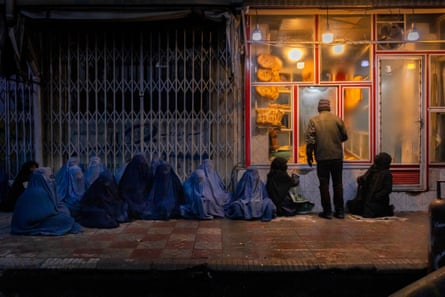 Women and children beg for bread outside a bakery in central Kabul, Afghanistan, 14 January 2022.