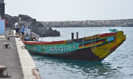 A long wooden boat moored at a dock