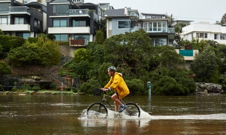 A cyclist rides through flood waters in Manly on Thursday.